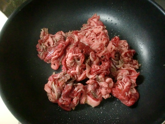フライパンに生姜の千切りと牛肉を入れて炒める